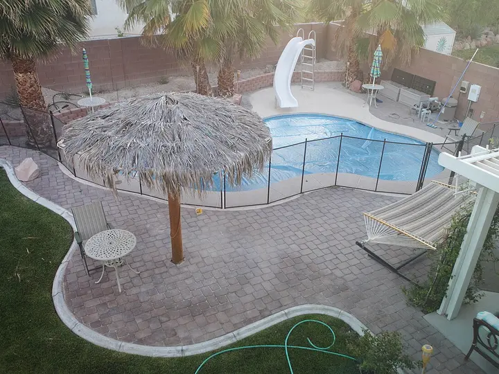 Backyard pool with a stone patio